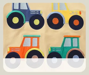Detail view of colorful cartoon tractor embroidery on beige cotton kids sweatshirt
