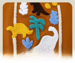Close-up of colorful towel embroidery featuring cute dinosaur patterns on orange knit fabric