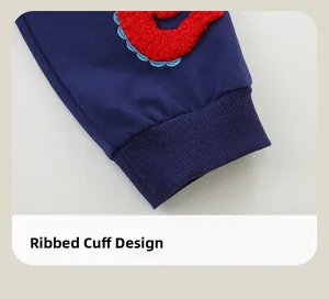 Detail of navy blue ribbed cuffs featuring premium red terry embroidery on kids' joggers