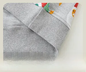 Détail de l'ourlet côtelé et coutures précises du sweat-shirt de Noël gris enfant
