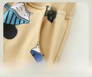Detail of khaki toddler trousers featuring car embroidery, elastic waist, and side pockets