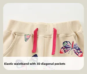 Détail de la taille élastique avec cordon rose et motif papillon sur le pantalon fille
