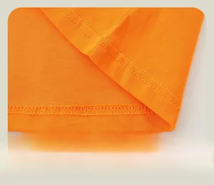 Detail of double-needle stitching on the hem of orange cotton dinosaur t-shirt