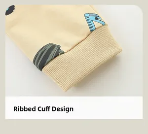 Close-up of elastic ribbed cuffs and cartoon excavator print on baby cotton tracksuit