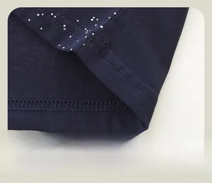 Détail de l'ourlet en maille bleu marine à pois blancs avec double couture solide