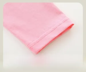 Gros plan des poignets à double couture lisse sur un t-shirt rose à manches longues fille