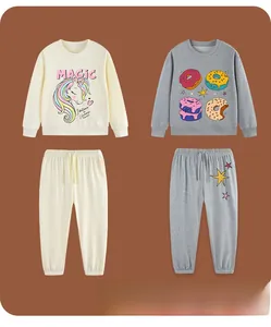 Flat lay of cream unicorn and grey donut pattern cotton sweatshirt and joggers sets