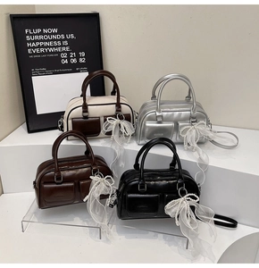 Detail of four Boston bags in cream, silver, brown, and black with pearl lace charms