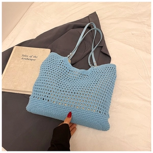 Close-up of sky blue crochet tote bag with mesh design and faux leather handles