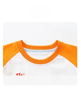 Detail view of the ribbed crew neck and contrast raglan sleeves on a boys cotton t-shirt