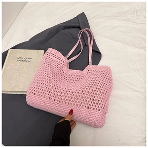 Detail of pink hand-woven tote bag showing hollow crochet texture and faux leather handles