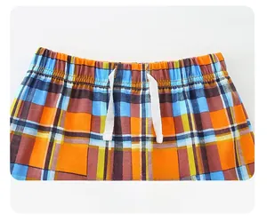 Detail view of boys plaid shorts with elastic waistband and white cotton drawstring