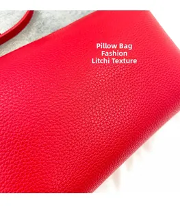 Dettaglio macro di borsa rossa a bauletto con trama in pelle motivo litchi pregiata
