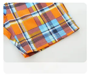 Detailed close-up of orange and blue plaid shorts hem with durable double stitching