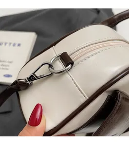 Detail of high-quality silver metal hardware and smooth cream leather on Boston bag