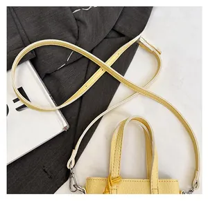 Détail de la bandoulière réglable et de la boucle argentée sur le sac en cuir jaune
