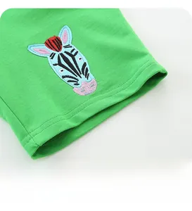Detail of green knit cotton shorts featuring a colorful zebra embroidery and flat stitching