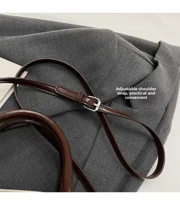 Detail of adjustable dark brown leather shoulder strap with silver buckle on Boston bag