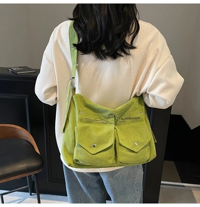 Détail du sac cabas en velours côtelé vert montrant les poches avant et la texture du tissu