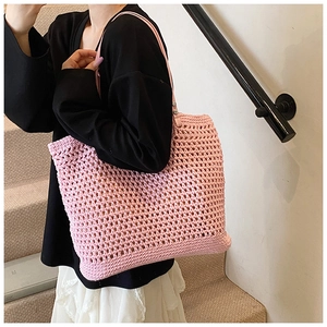 Detailed view of pink crochet tote bag texture with mesh pattern and shoulder straps