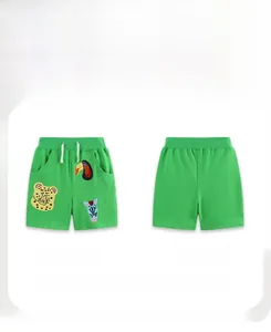 Detail of green boys' shorts with cartoon animal patches and adjustable white drawstring