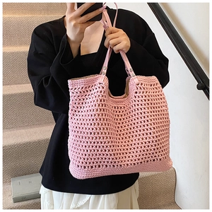 Detail of pink woven tote bag showing hollow mesh pattern and leather handle with rivets