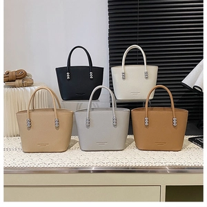 Detail of minimalist leather bucket bags in five colors with silver metal bead accents