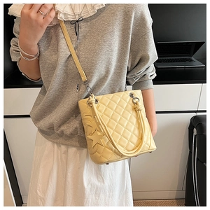 Détail du sac matelassé jaune crème avec pendentif étoile et bandoulière à la chaîne