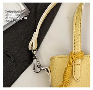 Détail du sac en cuir jaune avec bandoulière amovible et poignée en corde tressée