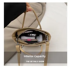 Internal capacity of beige pebble leather bucket bag showing phone and accessories