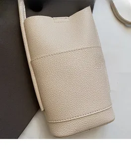 Close-up of off-white lychee pattern leather phone bag with fine stitching detail