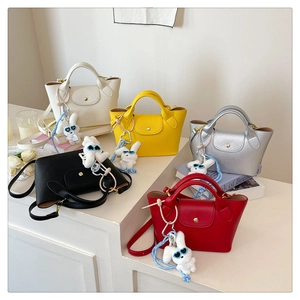 Mini tote bags in five colors with cute rabbit charms displayed on white steps