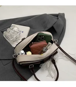 Interior view of bicolor Boston bag showing space for phone, wallet and perfume