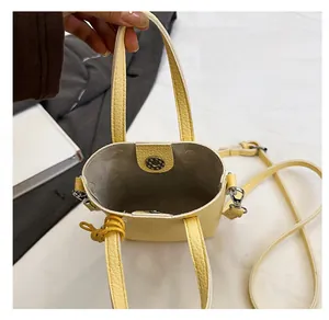 Vue de dessus de l'intérieur du sac seau en cuir jaune avec fermoir magnétique et anse