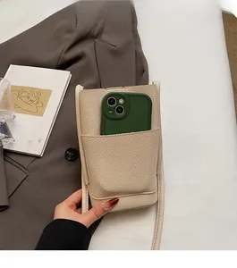Detail of cream lychee texture PU leather phone bag with a front pocket and slim strap