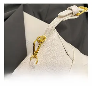 Detail of white lychee grain leather handbag with premium gold metal hook and strap
