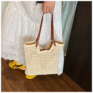 Detailed macro view of cream hand-woven crochet tote with brown leather handle