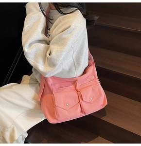 Détail du cabas en velours côtelé rose avec deux poches avant et boutons métalliques
