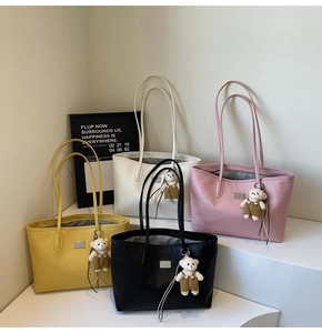 Close-up of pebble leather tote bags in four colors featuring cute bear bag charms