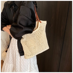 Detail of hand-woven cream tote bag with brown leather straps and metal rivets