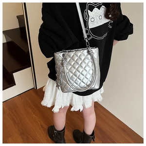 Sac fourre-tout argenté matelassé avec breloques étoiles dans un décor intérieur