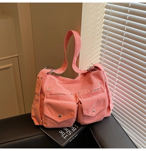 Détail macro du sac cabas en velours côtelé rose avec poches fonctionnelles et texture tissu