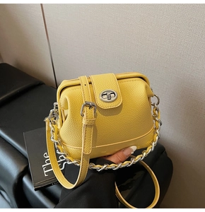 Detail of yellow lychee grain leather handbag with silver chain and twist lock