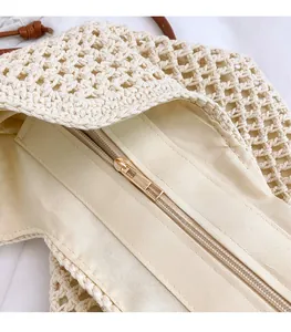 Detail view of woven bag featuring fabric lining, secure zipper, and gold hardware head