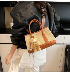 Détail du sac fourre-tout en paille avec bordure en cuir marron et bandoulière géométrique