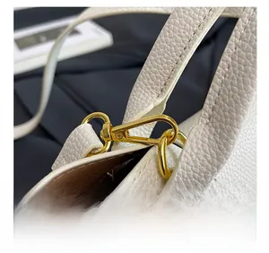 Macro shot of premium white lychee grain leather texture and gold metal hook detail