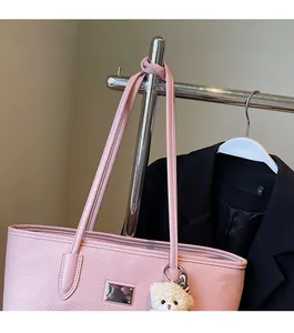 Detail of pink lychee leather tote bag with silver plate and cute white bear charm