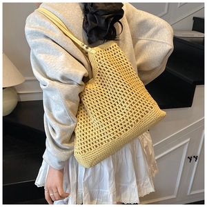 Detail of a bright yellow hand-woven hollow tote bag with a minimalist mesh texture