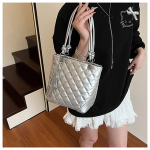 Détail du sac cabas argenté matelassé avec finition métallisée et charms étoiles