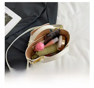 Interior view of white mini tote bag showing capacity with phone, makeup and umbrella